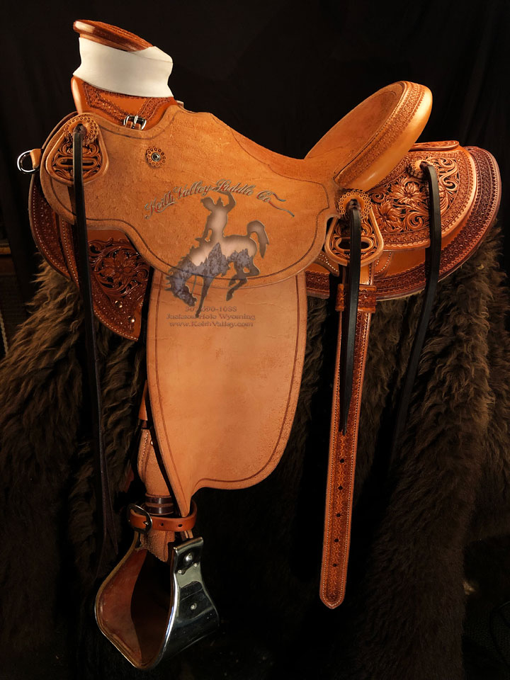 The flaming Jackson Floral half breed Wade. 90 degree North West bars 
                    3inch high x 5 - 1/4 inch Wide by 5 - 1/2inch length - Guadalajara post horn with pearl mule hide wrap. 15 & 1/2 inch - close contact seat, Cantle is 12 & 1/2 inch wide by 4 inch high with 1 & 3/4inch Cheyenne roll. Tooled half breed with Vaquero lace border and Sheridan floral with Flaming Jackson Rose (resembling Indian paint brush) hand painted black background.  Sporting hard to come by Harwood stainless steel hardware